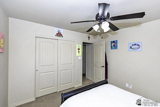 carpeted bedroom featuring ceiling fan and a closet