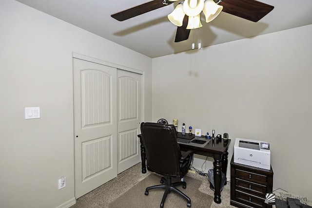 carpeted office space with ceiling fan