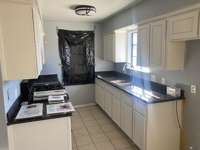 kitchen featuring light tile patterned floors, white cabinetry, and sink