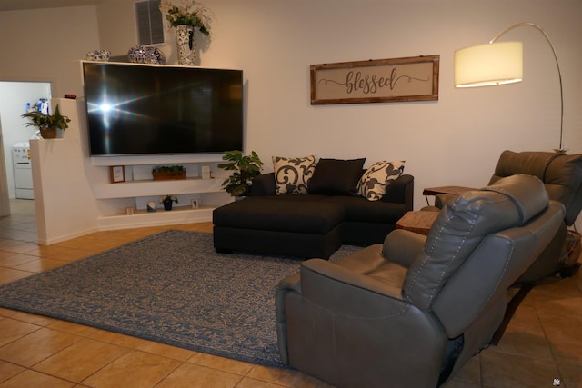 tiled living room featuring washer / dryer