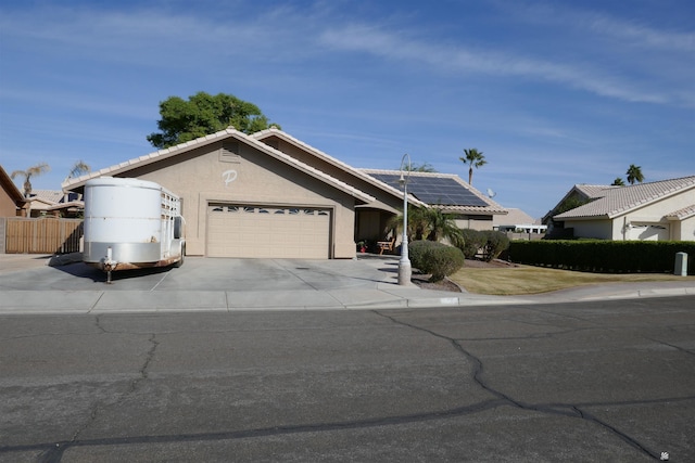 single story home with solar panels and a garage