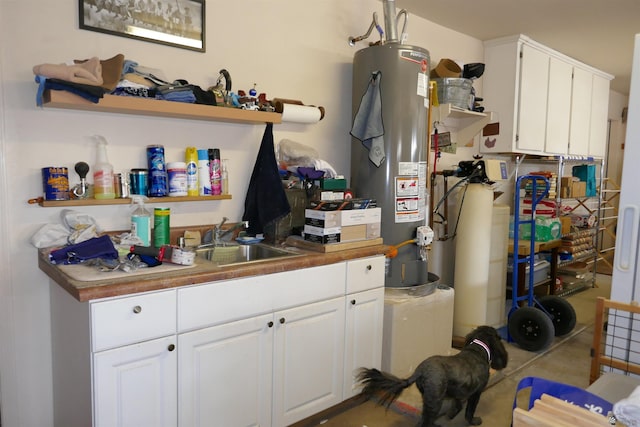 kitchen featuring white cabinets, gas water heater, and sink