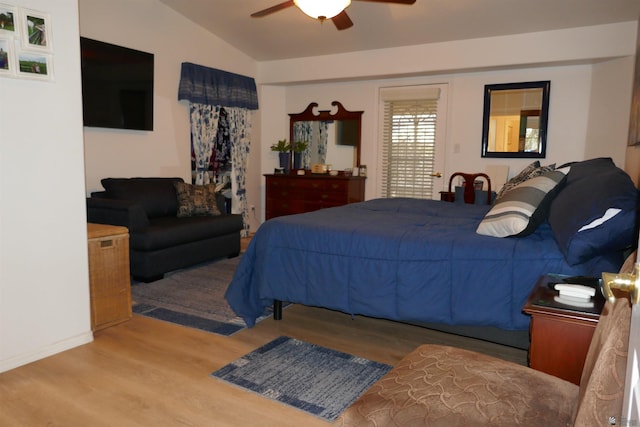 bedroom with ceiling fan, lofted ceiling, and light hardwood / wood-style flooring