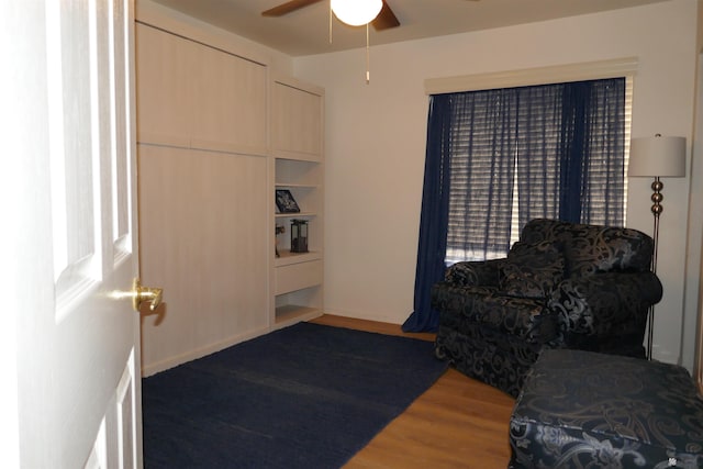 living area featuring hardwood / wood-style flooring, ceiling fan, and built in features