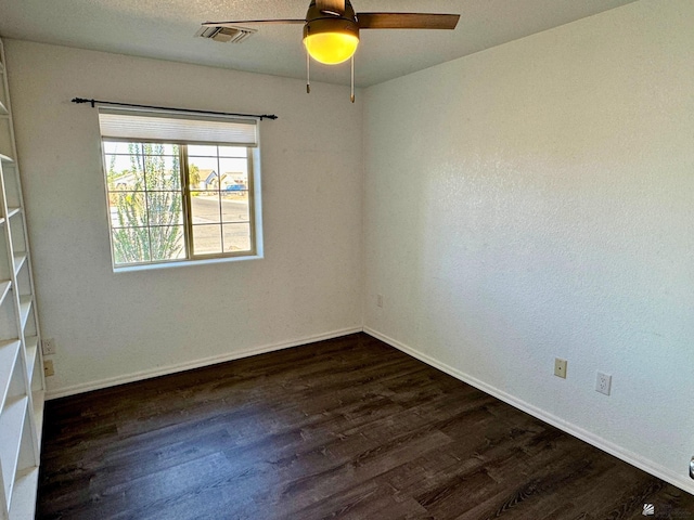 empty room featuring ceiling fan and dark wood-type flooring