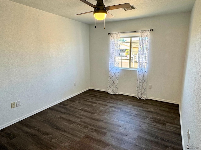 empty room with ceiling fan, dark hardwood / wood-style flooring, and a textured ceiling