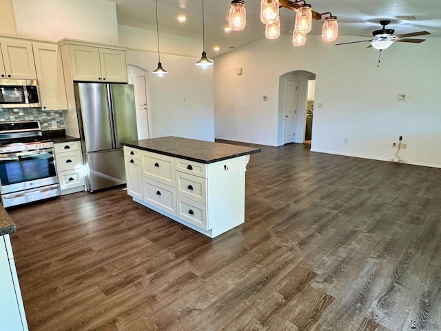 kitchen with tasteful backsplash, white cabinetry, hanging light fixtures, and appliances with stainless steel finishes