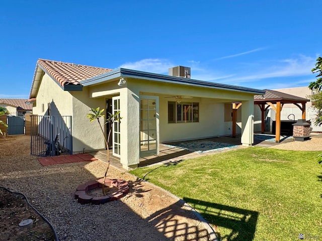 rear view of property featuring a gazebo, cooling unit, a patio area, and a yard