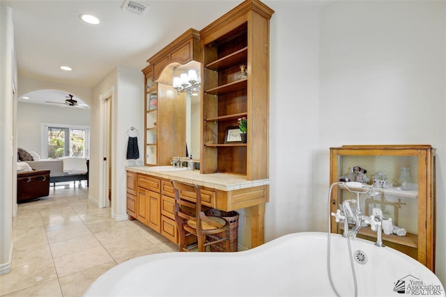 bathroom with tile patterned flooring, a bath, vanity, and ceiling fan