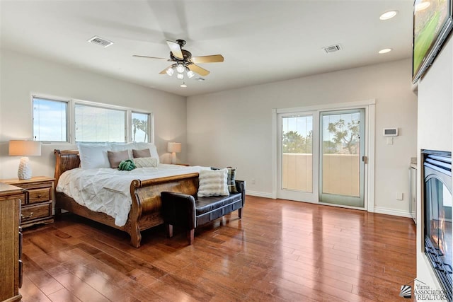 bedroom featuring multiple windows, access to outside, ceiling fan, and hardwood / wood-style flooring