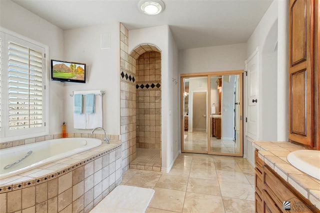 bathroom with tile patterned flooring, vanity, and separate shower and tub