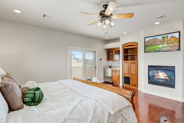 bedroom featuring access to exterior, ceiling fan, dark hardwood / wood-style flooring, and fridge