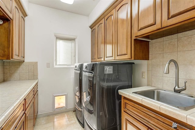 laundry room with cabinets, separate washer and dryer, and sink