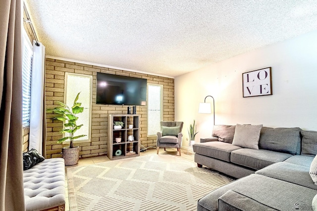 living room featuring a wealth of natural light, a textured ceiling, and brick wall