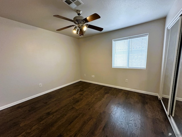 spare room with ceiling fan and dark hardwood / wood-style flooring