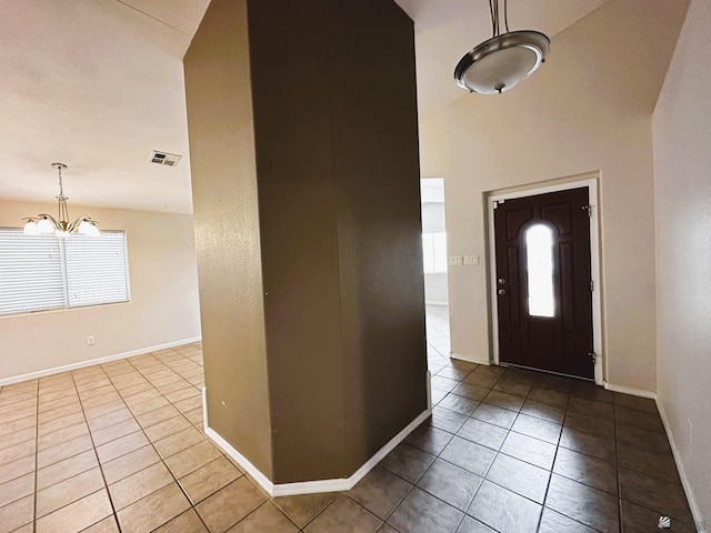 foyer entrance featuring a notable chandelier and light tile patterned floors