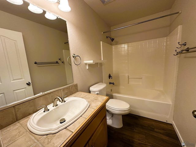 full bathroom with toilet, vanity, hardwood / wood-style flooring, shower / bathtub combination, and backsplash