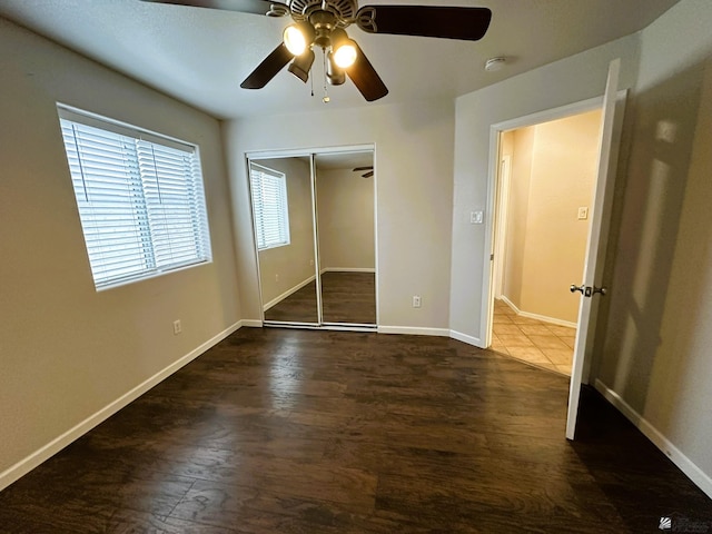 unfurnished bedroom with ceiling fan, a closet, and dark hardwood / wood-style floors