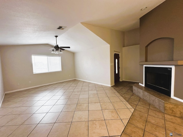 unfurnished living room with ceiling fan, lofted ceiling, a textured ceiling, and light tile patterned floors