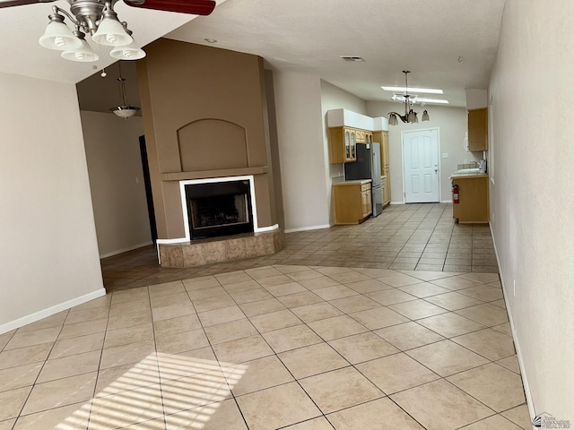 unfurnished living room with sink, light tile patterned flooring, and vaulted ceiling