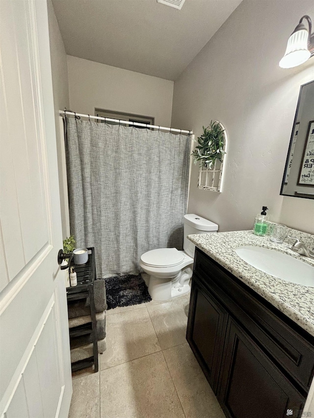 bathroom featuring tile patterned flooring, vanity, and toilet