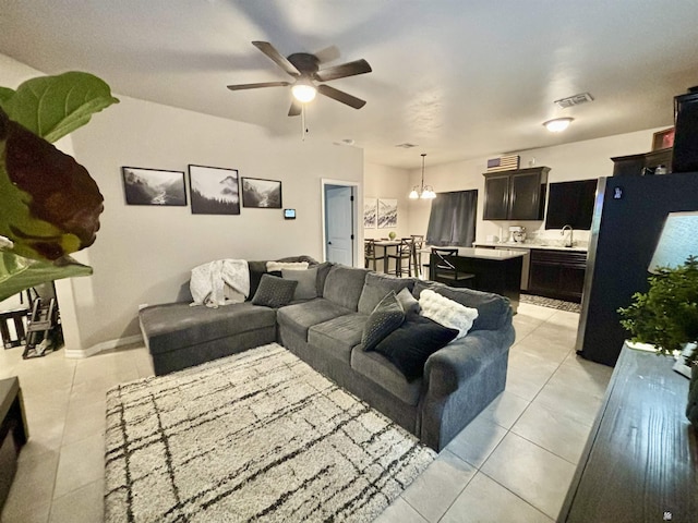 tiled living room with ceiling fan with notable chandelier and sink