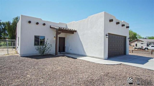 pueblo revival-style home featuring a garage