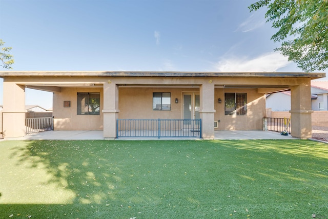 rear view of house with a lawn and a patio area