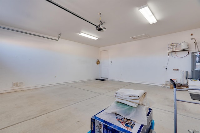 garage with a garage door opener and strapped water heater