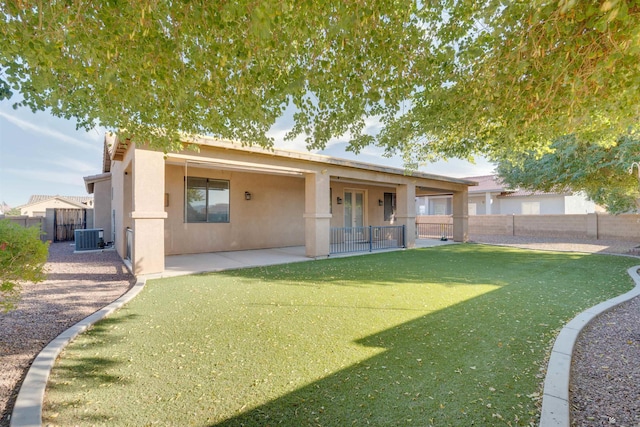 rear view of house featuring a yard, a patio area, and cooling unit