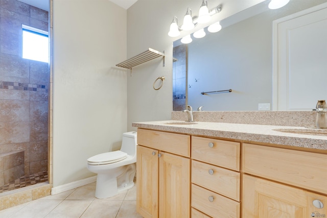 bathroom with toilet, tile patterned flooring, a tile shower, and vanity