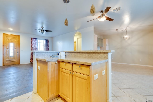 kitchen with a center island, ceiling fan, light tile patterned floors, light brown cabinetry, and pendant lighting