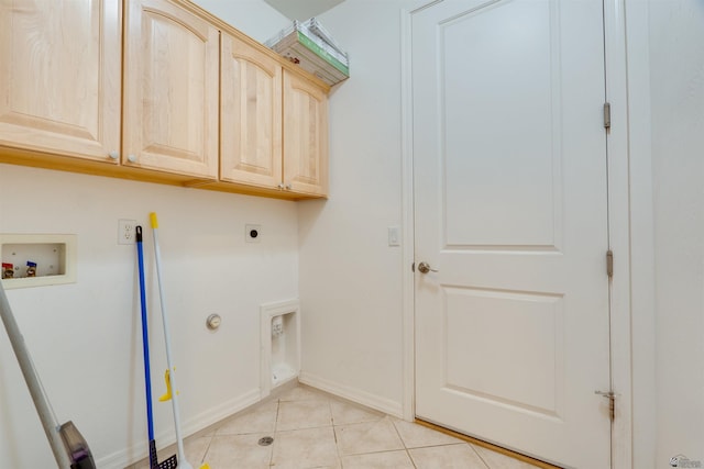 clothes washing area with hookup for an electric dryer, cabinets, washer hookup, and light tile patterned floors