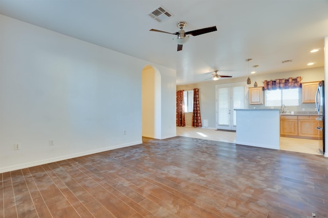 unfurnished living room featuring wood-type flooring and ceiling fan