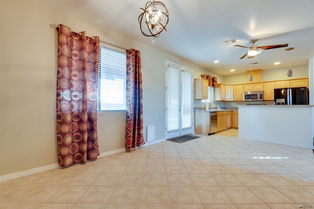 kitchen featuring appliances with stainless steel finishes, light tile patterned flooring, pendant lighting, and light brown cabinets