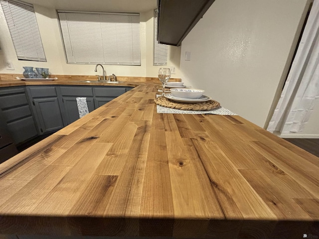 kitchen featuring butcher block counters, sink, gray cabinetry, and wood-type flooring