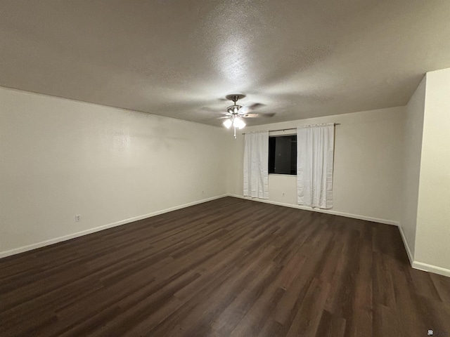 empty room featuring ceiling fan, dark hardwood / wood-style flooring, and a textured ceiling