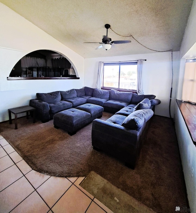 living room featuring ceiling fan, a textured ceiling, and tile patterned floors