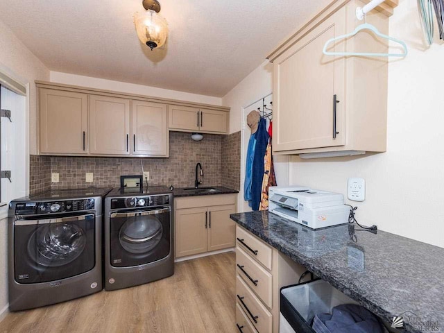 laundry room featuring cabinets, separate washer and dryer, sink, and light hardwood / wood-style flooring