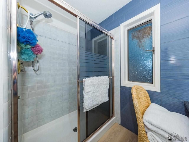 bathroom featuring wood-type flooring and a shower with door