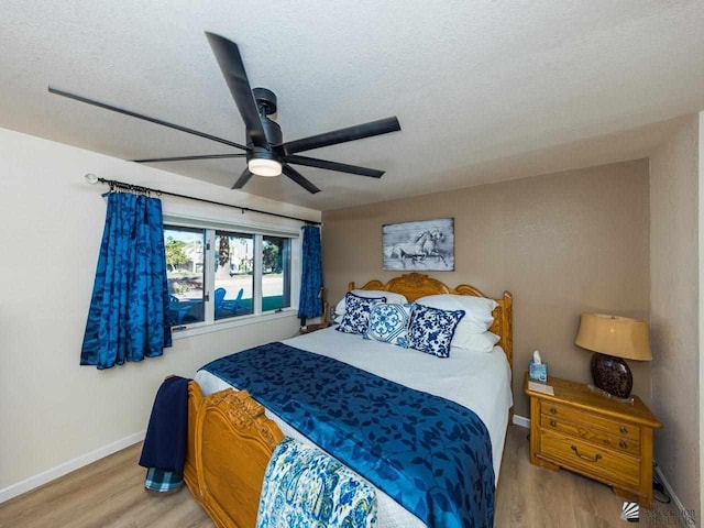 bedroom featuring wood-type flooring, a textured ceiling, and ceiling fan