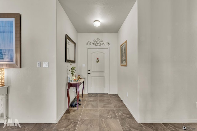 foyer entrance featuring baseboards