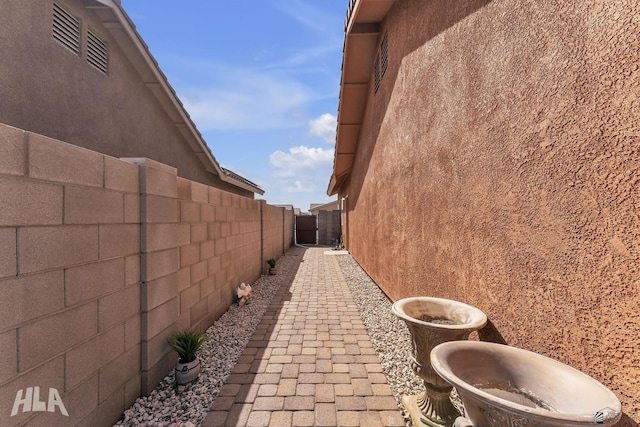 view of side of home with fence and stucco siding