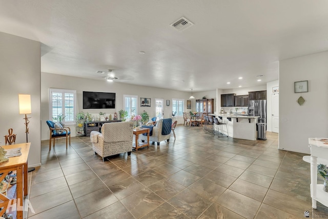 living area with light tile patterned floors, baseboards, and visible vents