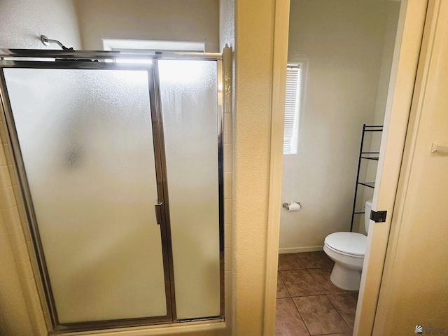 full bath with a shower stall, toilet, and tile patterned floors