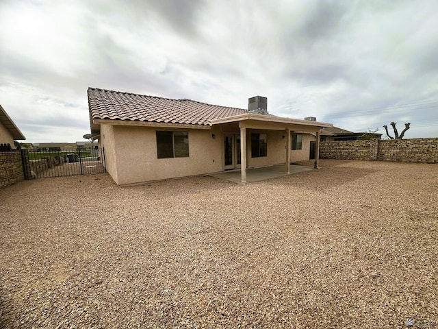 rear view of house featuring a tile roof, a patio, stucco siding, cooling unit, and a fenced backyard