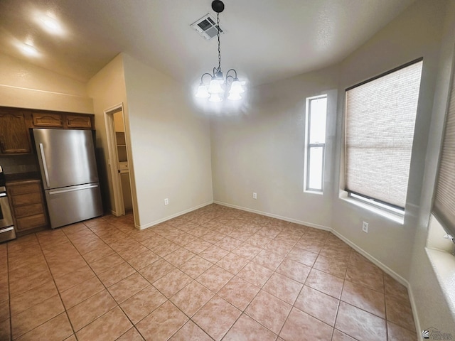 unfurnished dining area featuring light tile patterned floors, baseboards, visible vents, and an inviting chandelier