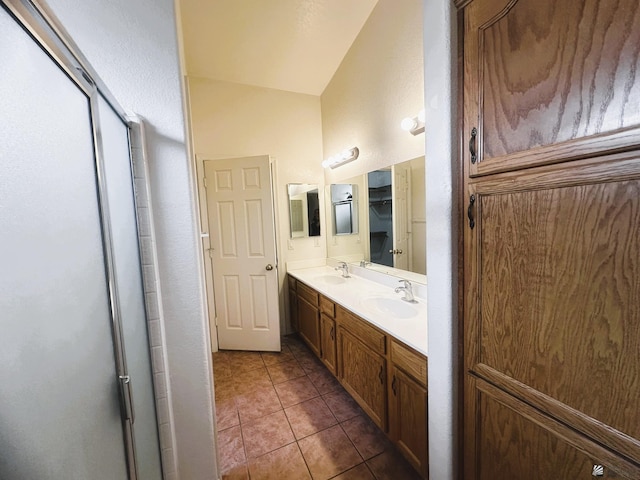 full bathroom featuring double vanity, a sink, a shower with door, and tile patterned floors