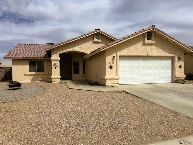 view of front of house featuring a garage, driveway, and stucco siding