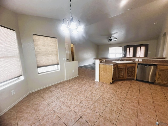 kitchen featuring hanging light fixtures, stainless steel dishwasher, open floor plan, light tile patterned flooring, and a sink